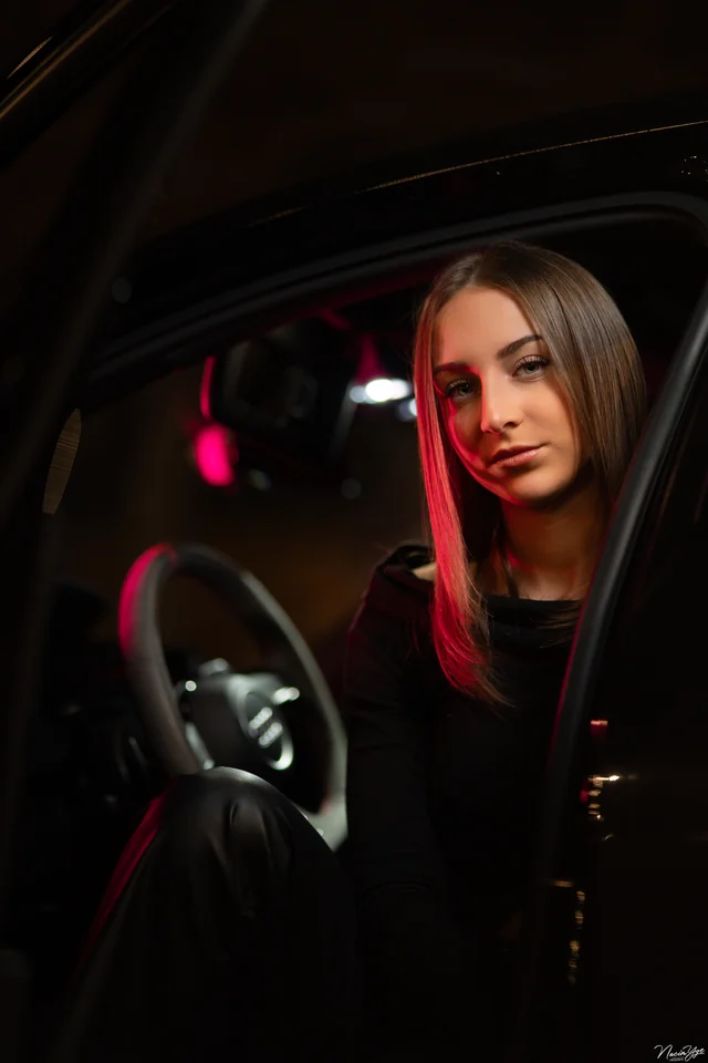 Portrait d’une femme à bord d’une voiture dans une lumière rouge