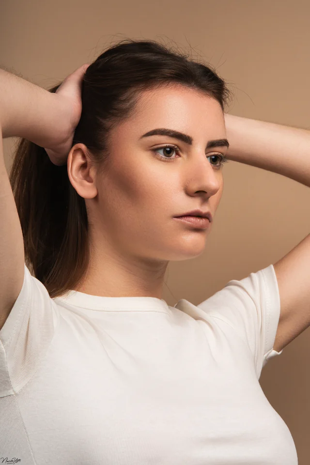 Portrait en studio d’une femme les mains dans les cheveux