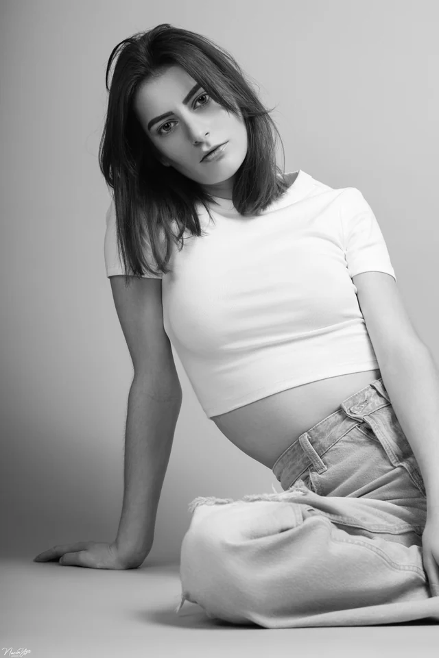 Portrait en noir et blanc d’une femme assise en studio