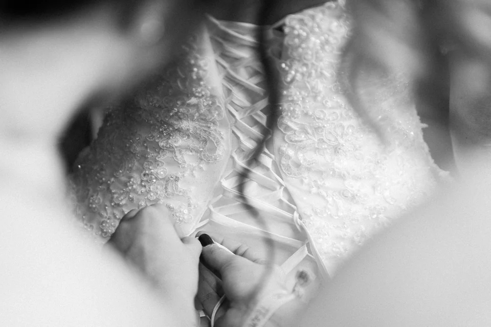 Détail en noir et blanc du laçage d’une robe de mariée