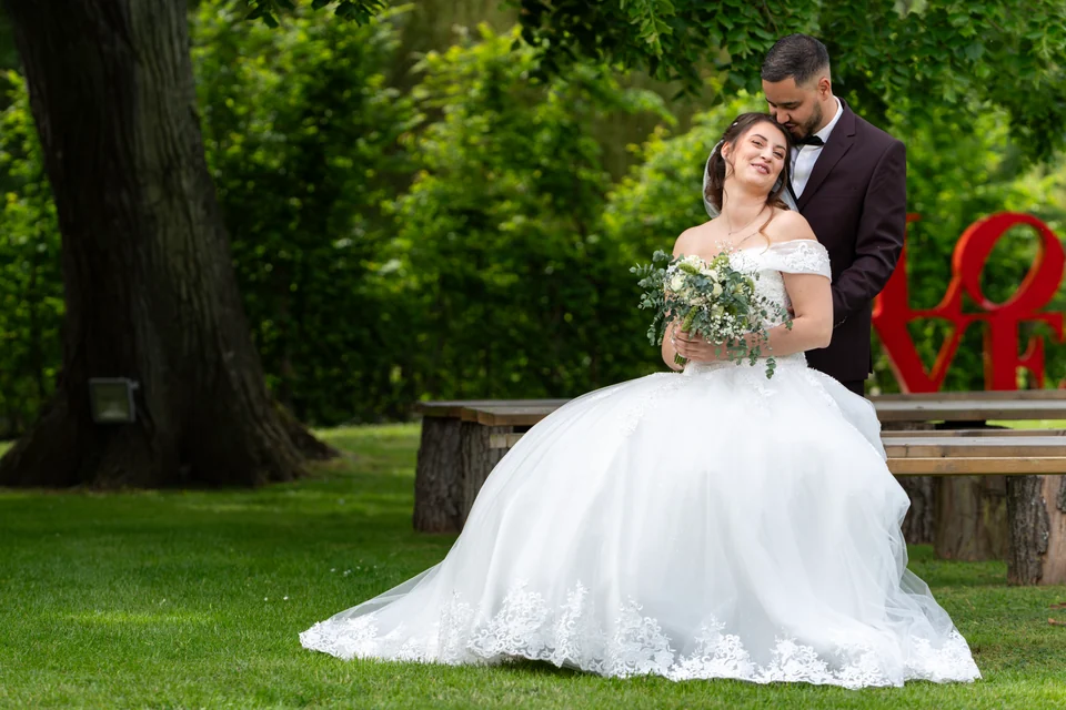 Couple de mariés enlacé dans un jardin